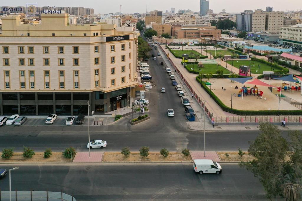 Romera Hotel في جدة: شارع المدينة فيه سيارات تقف في موقف للسيارات