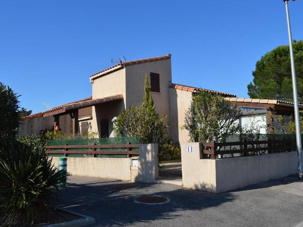 une maison avec une clôture devant dans l'établissement Villa climatisée 3 pièces, 6 couchages avec terrasse, piscine et parking à Saint-Cyprien - FR-1-225D-532, à Saint Cyprien Plage