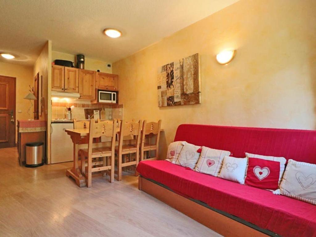 a living room with a red couch and a kitchen at Appartement Montvalezan-La Rosière, 2 pièces, 6 personnes - FR-1-398-507 in La Rosière