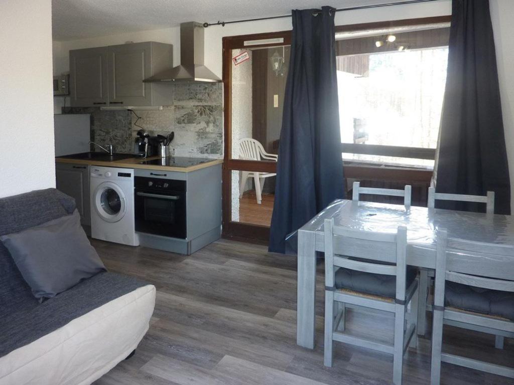 a kitchen and living room with a dining table and a table and chairs at Appartement Les Orres, 2 pièces, 6 personnes - FR-1-322-311 in Les Orres