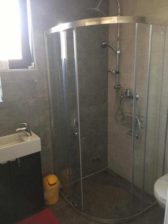 a shower with a glass door in a bathroom at Guesthouse Family Bosnic in Plitvička Jezera