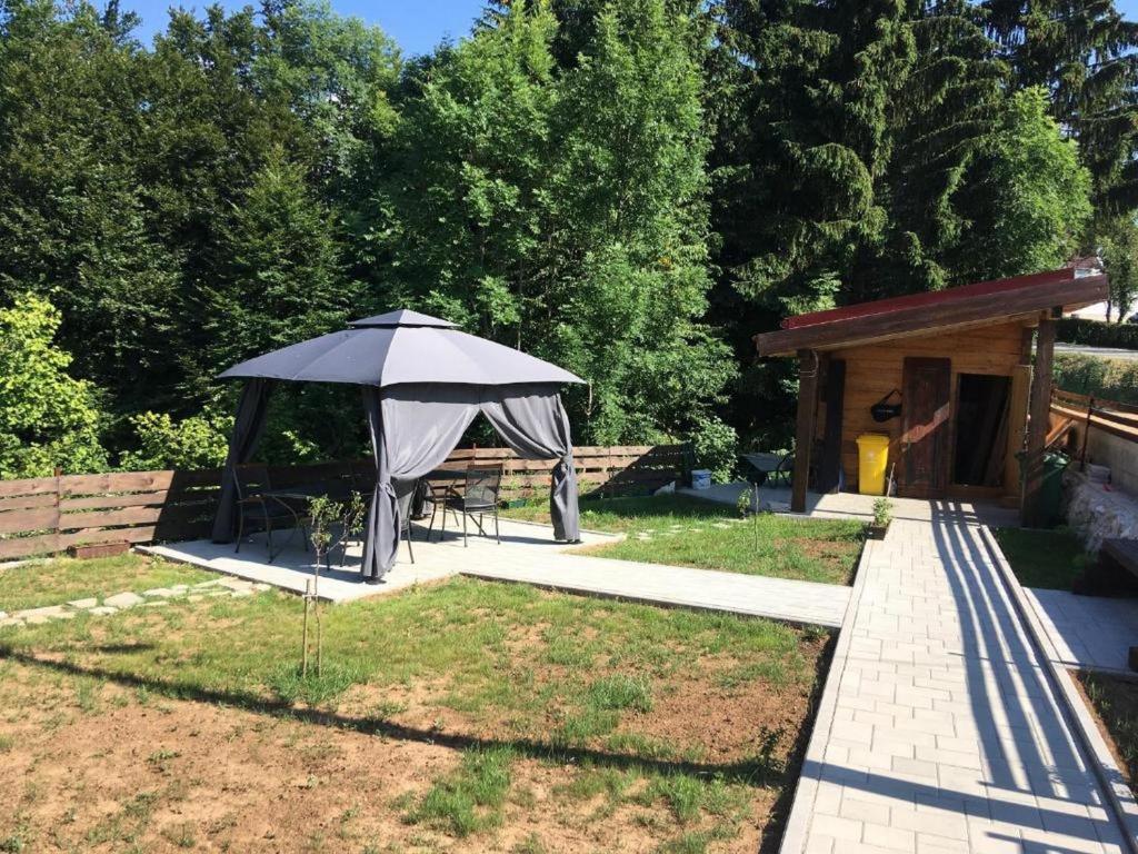 a gazebo with a table and an umbrella at Guesthouse Family Bosnic in Plitvička Jezera