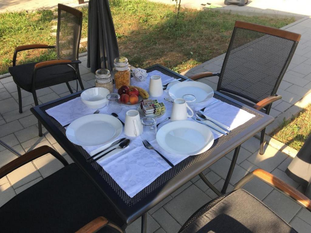 a table with plates and utensils on top at Guesthouse Family Bosnic in Plitvička Jezera