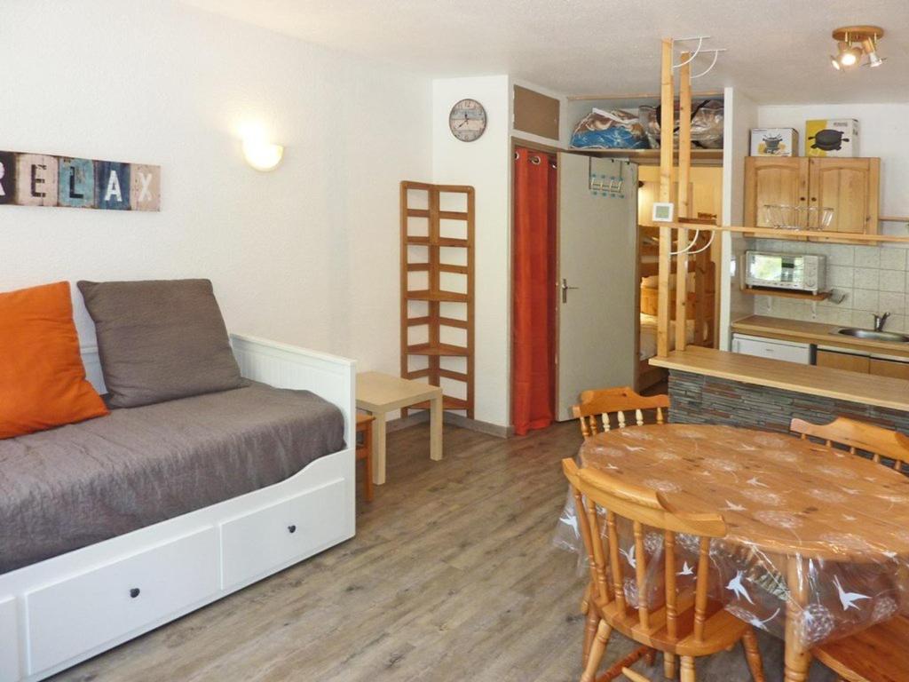 a bedroom with a bed and a table and a kitchen at Studio Les Orres, 1 pièce, 4 personnes - FR-1-322-319 in Les Orres