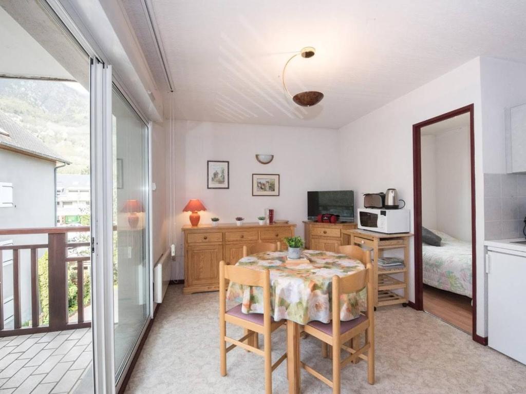une salle à manger avec une table et une cuisine dans l'établissement Appartement ensoleillé 4 pers, proche thermes et télécabine, avec balcon et parking, Saint-Lary-Soulan - FR-1-296-264, à Saint-Lary-Soulan