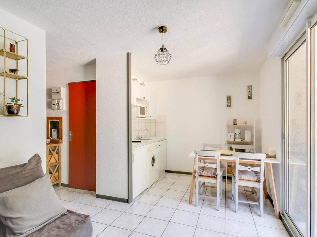 une cuisine et une salle à manger avec une table et des chaises dans l'établissement Studio cabine avec parking proche centre Luz-Saint-Sauveur, balcon, pour 4 pers. - FR-1-402-66, à Luz-Saint-Sauveur