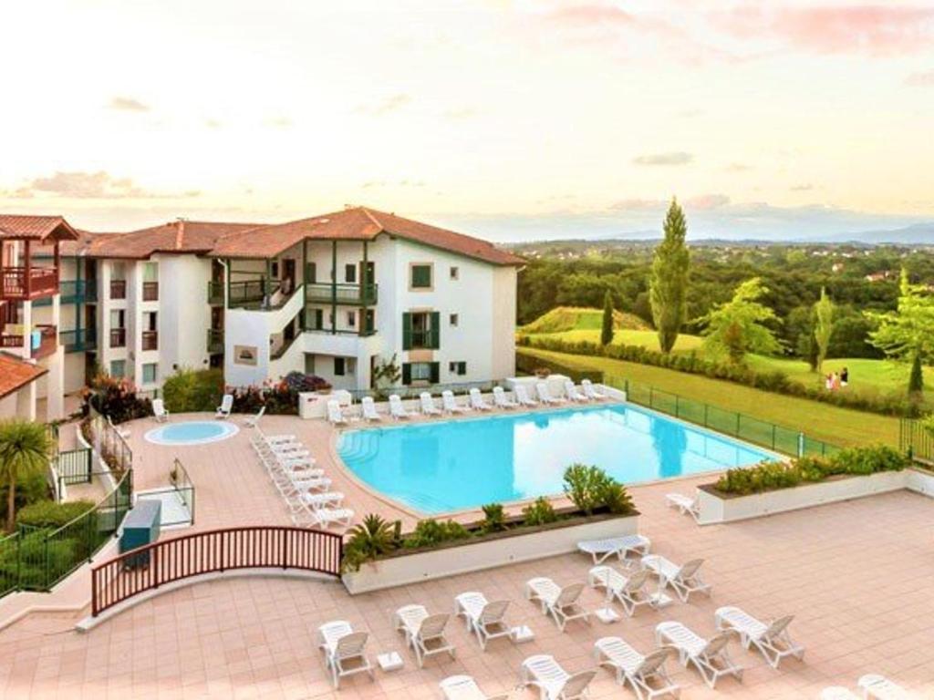a resort with a pool and chairs and a building at Appartement Arcangues, 3 pièces, 4 personnes - FR-1-3-475 in Arcangues