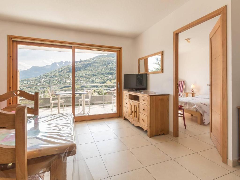 ブリアンソンにあるAppartement Briançon, 2 pièces, 4 personnes - FR-1-330C-58のベッド、テレビ、バルコニーが備わる客室です。