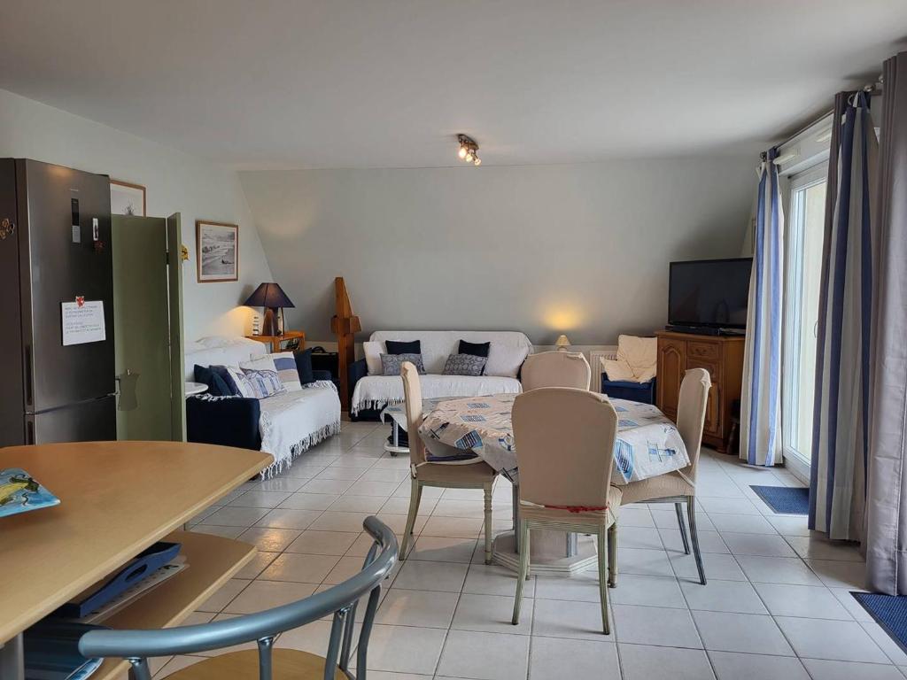 une chambre avec deux lits, une table et des chaises dans l'établissement Appartement 2 pièces avec piscine et parking privé, proche plage, Merville-Franceville-Plage - FR-1-465-26, à Merville-Franceville-Plage