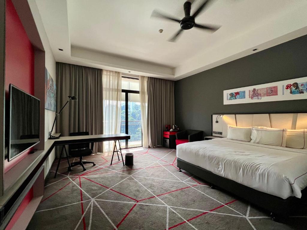 a bedroom with a bed and a desk and a television at The RED in Kuala Lumpur