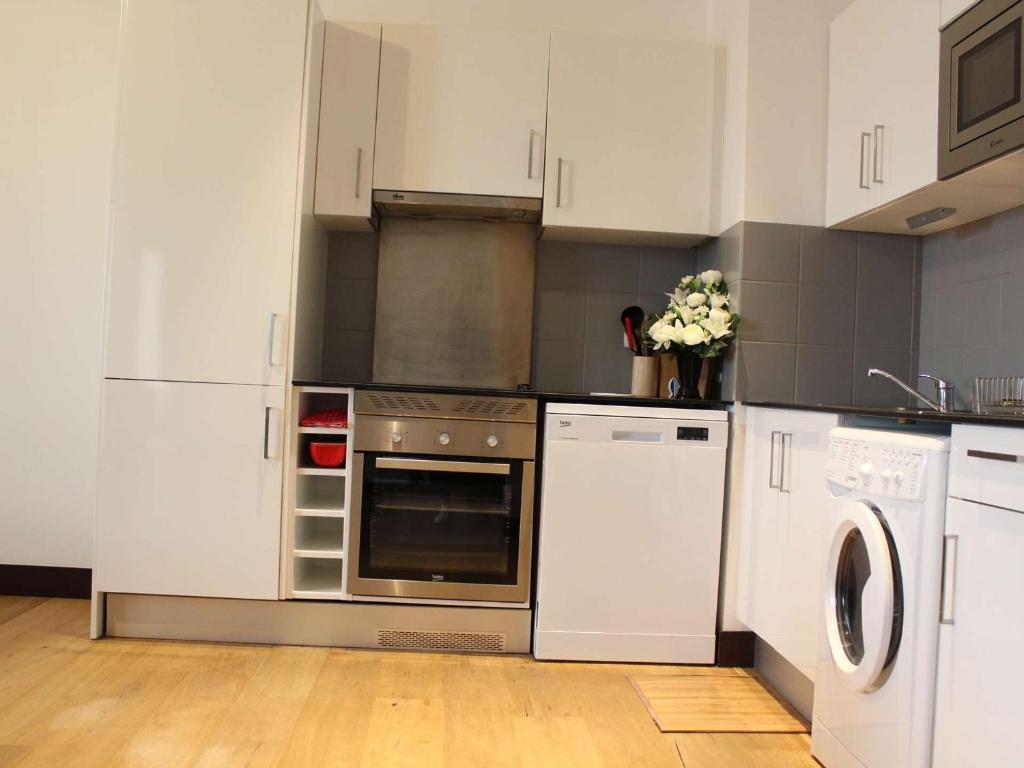 una cocina con electrodomésticos blancos y armarios blancos en Appartement Rochefort, 3 pièces, 4 personnes - FR-1-246B-462, en Rochefort