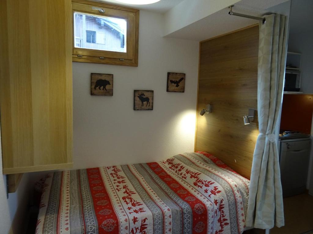 a bedroom with a bed with a wooden door at Appartement Peisey-Vallandry, 2 pièces, 5 personnes - FR-1-411-527 in Landry