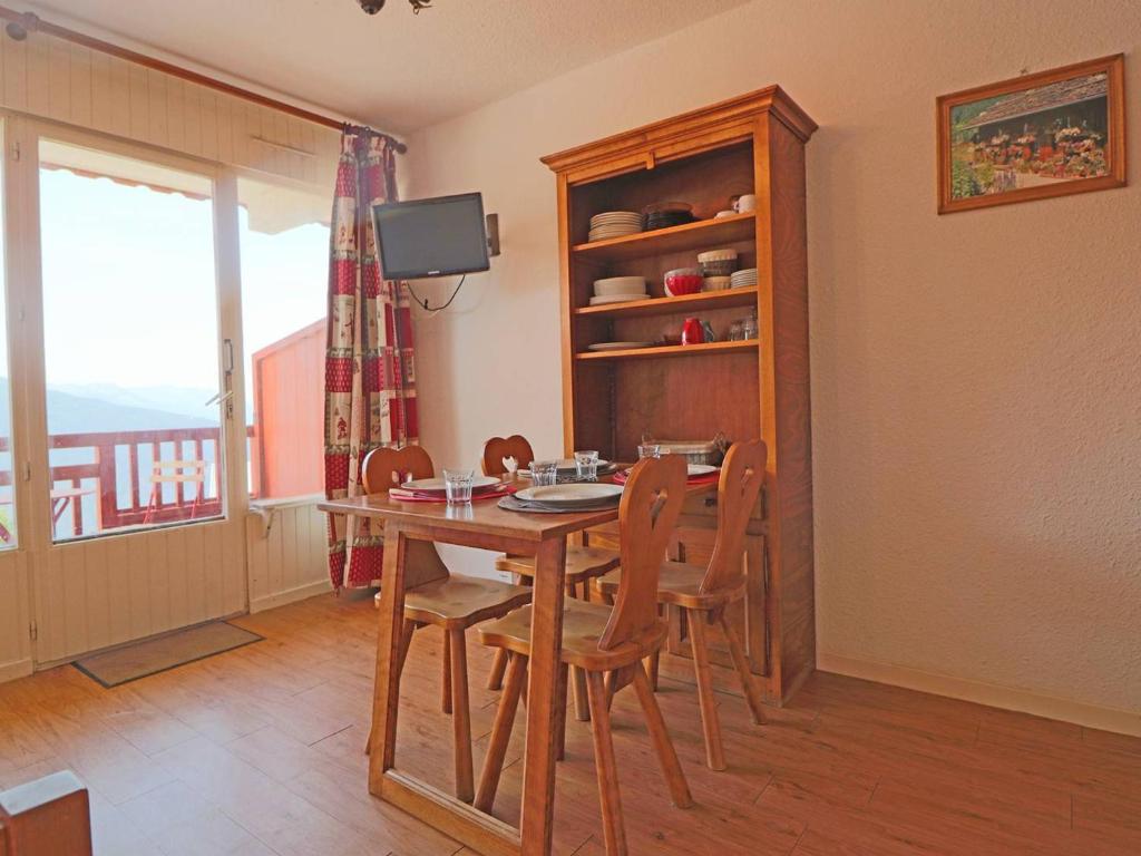 a dining room with a wooden table and chairs at Studio Montvalezan-La Rosière, 1 pièce, 4 personnes - FR-1-398-575 in La Rosière