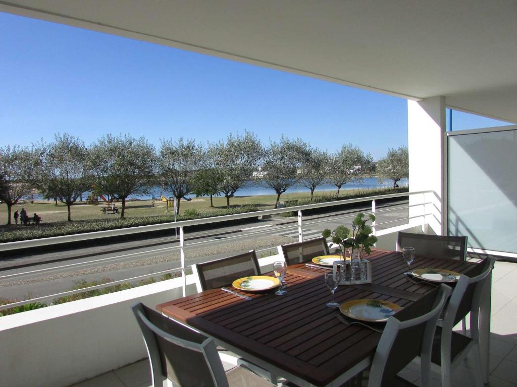- une table à manger sur un balcon avec vue sur l'eau dans l'établissement Appartement Étel, 2 pièces, 4 personnes - FR-1-479-68, à Étel