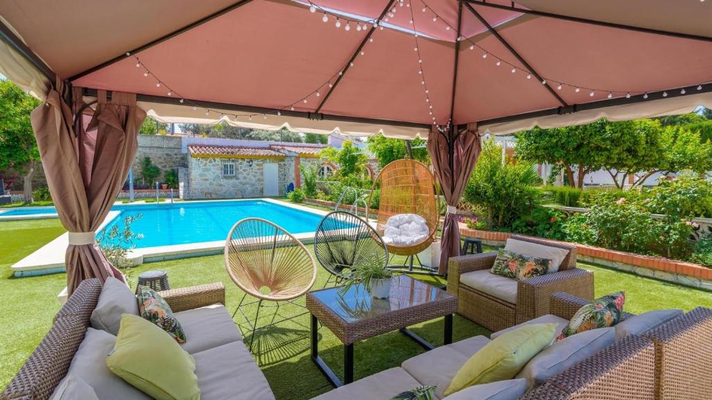 une terrasse avec une table, des chaises et une piscine dans l'établissement Casa rural cerca de Aracena Castillo de las Guardas by Ruralidays, à Séville