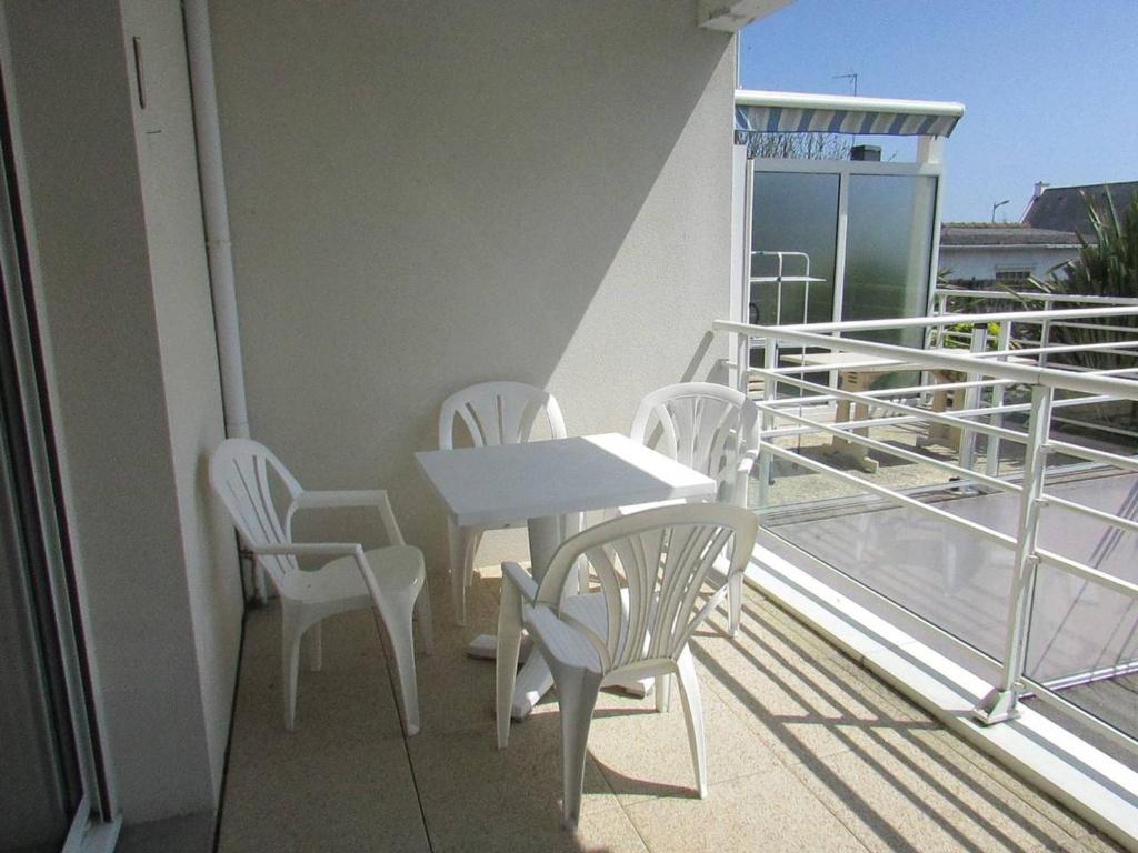 a balcony with a table and chairs on a ship at Appartement Étel, 2 pièces, 4 personnes - FR-1-479-88 in Étel