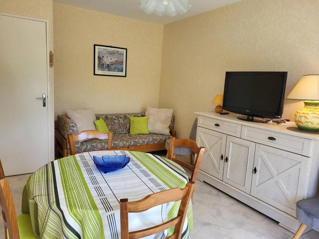 un salon avec un canapé et une télévision à écran plat dans l'établissement Appartement T2 au cœur de Cabourg avec balcon, parking & acceptant animaux - FR-1-465-16, à Cabourg