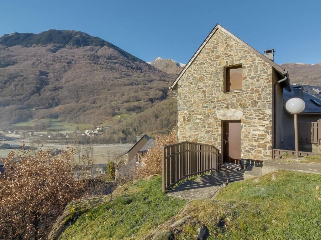 a stone house on a hill with mountains in the background at Appartement Esquièze-Sère, 3 pièces, 4 personnes - FR-1-402-82 in Esquièze - Sère
