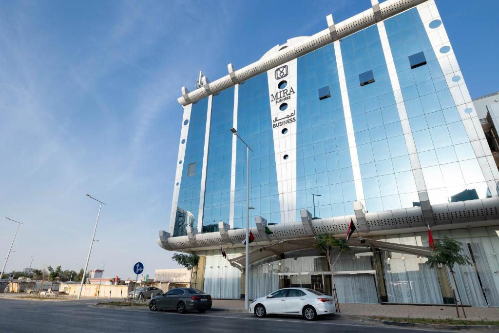 Mira Business Hotel في الرياض: مبنى فيه سيارات تقف امامه