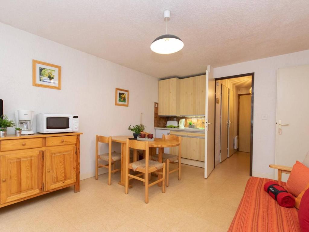 a kitchen and dining room with a table and a microwave at Appartement T2 pour 4 pers. à Saint-Lary Soulan, prox. centre et téléphérique, balcon, navette gratuite - FR-1-296-281 in Saint-Lary-Soulan
