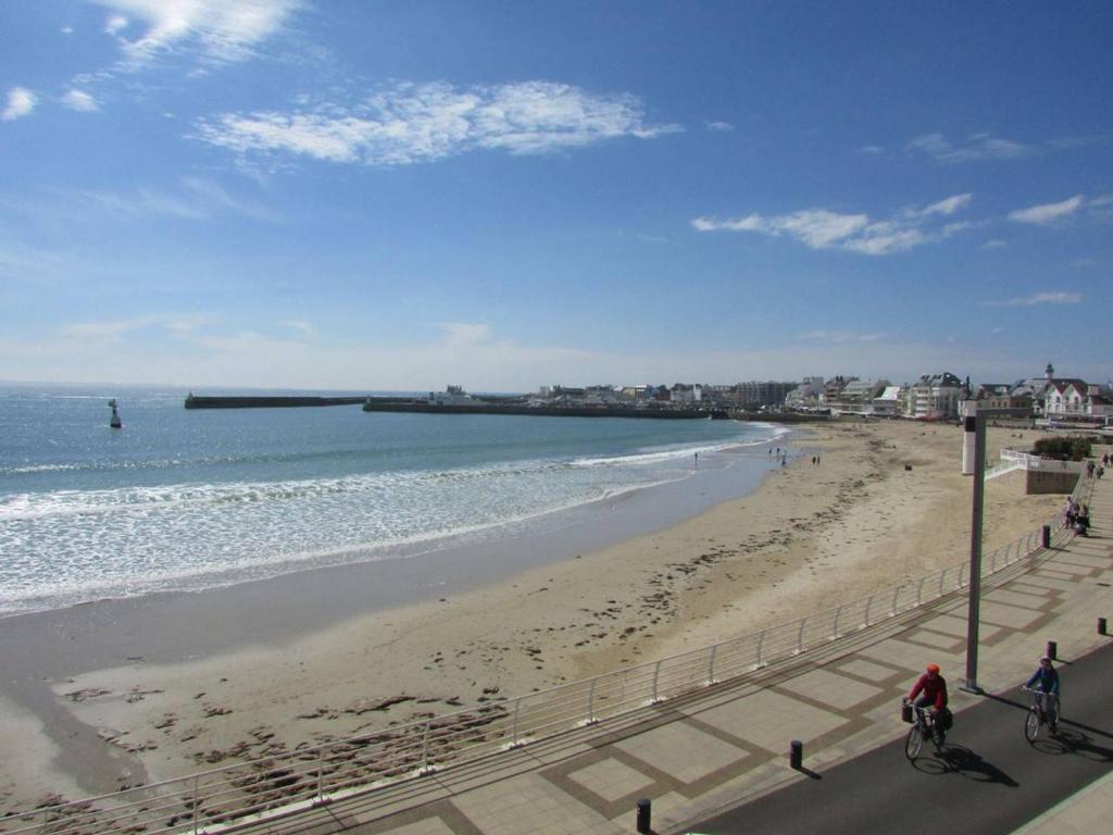 a view of a beach with people riding bikes at Quiberon - Grand 2 pièces avec balcon et parking, face à la plage - FR-1-478-4 in Quiberon