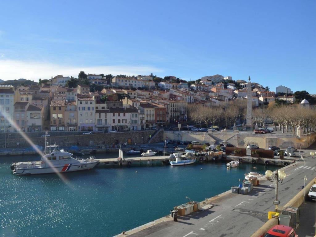 un groupe de bateaux amarrés dans un port avec une ville dans l'établissement Appart 2 pièces à Port-Vendres, 4 personnes, proche centre et criée, animaux admis - FR-1-225C-8, à Port-Vendres