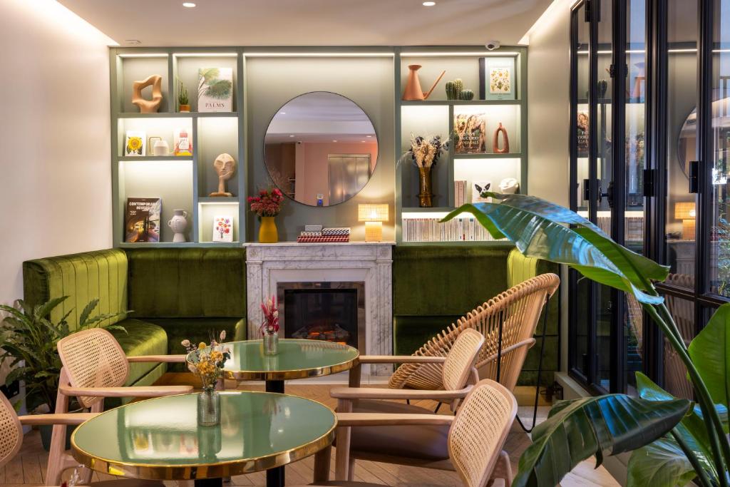 a room with tables and chairs and a fireplace at Hôtel La Canopée in Paris