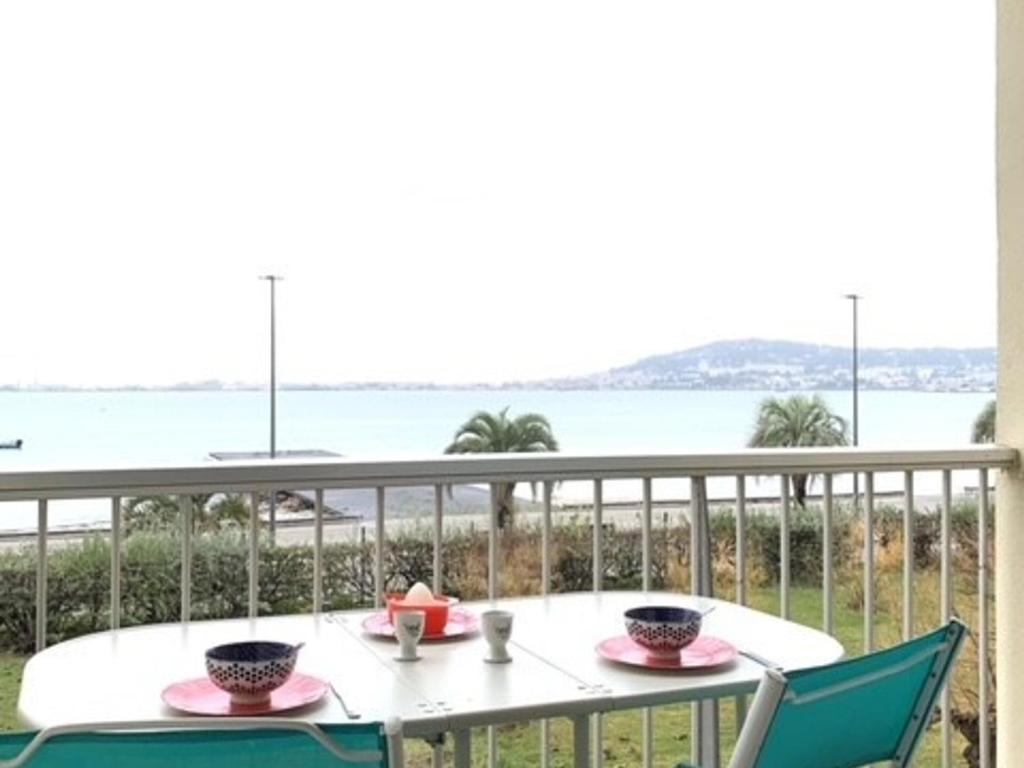 une table et des chaises sur un balcon avec vue sur l'océan dans l'établissement 1er étage, balcon, animaux admis, parking de proximité - FR-1-503-8, à Balaruc-les-Bains