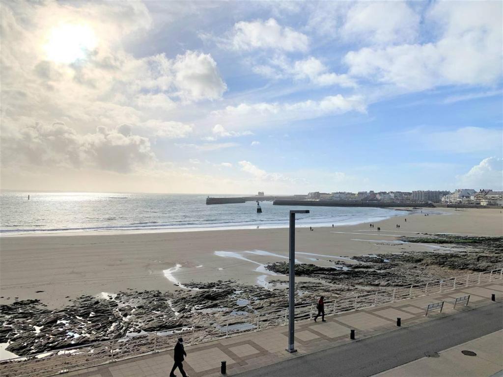 - une plage avec des personnes se promenant sur le sable et l'océan dans l'établissement Studio cosy à Quiberon avec parking et animaux admis, face à la mer - FR-1-478-87, à Quiberon