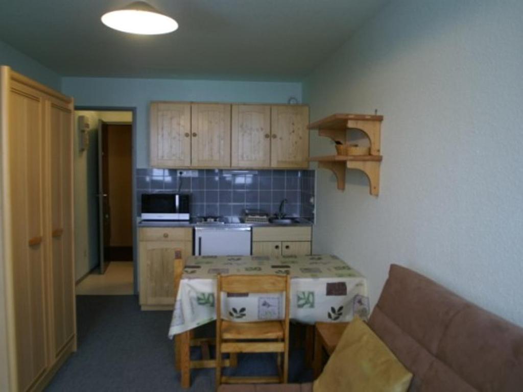 - une petite cuisine avec une table et un comptoir dans l'établissement Appartement Le Pleynet, 1 pièce, 3 personnes - FR-1-557A-18, à La Ferrière