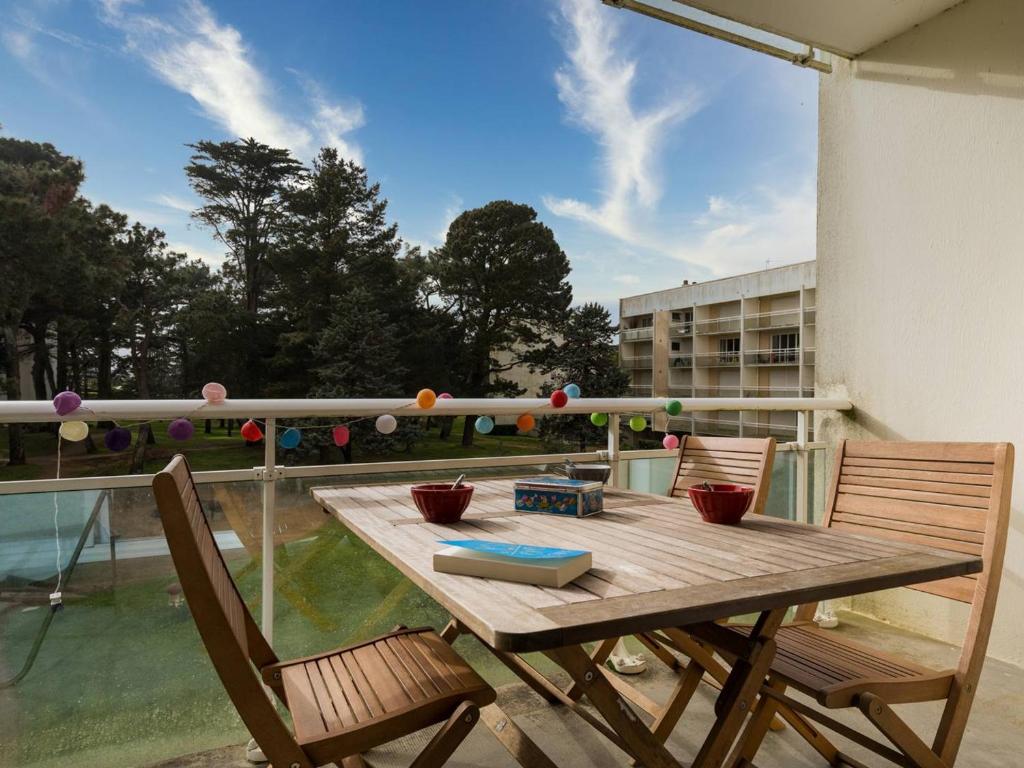 a wooden table and two chairs on a balcony at Carnac Plage: Grand 3P avec Loggia, Wifi, Parking, proche commerces et plage - FR-1-477-30 in Carnac