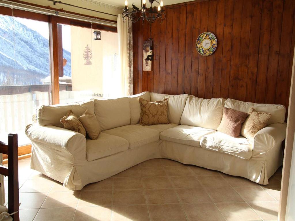 - un canapé blanc dans le salon doté d'une fenêtre dans l'établissement Appartement à Montgenèvre, 5 couchages, balcon sud, parking, animaux admis, proche des pistes - FR-1-330D-121, à Montgenèvre