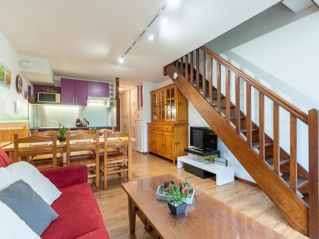 a living room and kitchen with a red couch and a table at Appartement duplex Saint-Lary 6 pers, 2 ch, mezzanine, balcon - FR-1-296-302 in Saint-Lary-Soulan