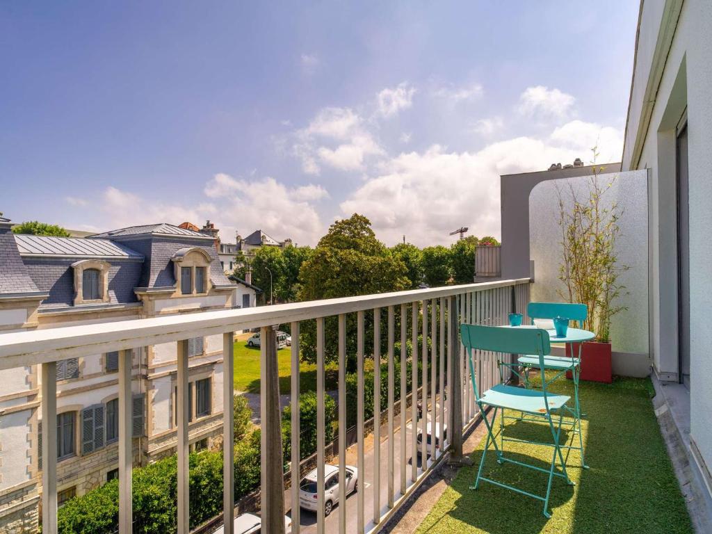 d'un balcon avec deux chaises et une vue sur la rue. dans l'établissement Studio rénové avec balcon, quartier Saint Charles, à 800m de la plage du Miramar - FR-1-3-465, à Biarritz