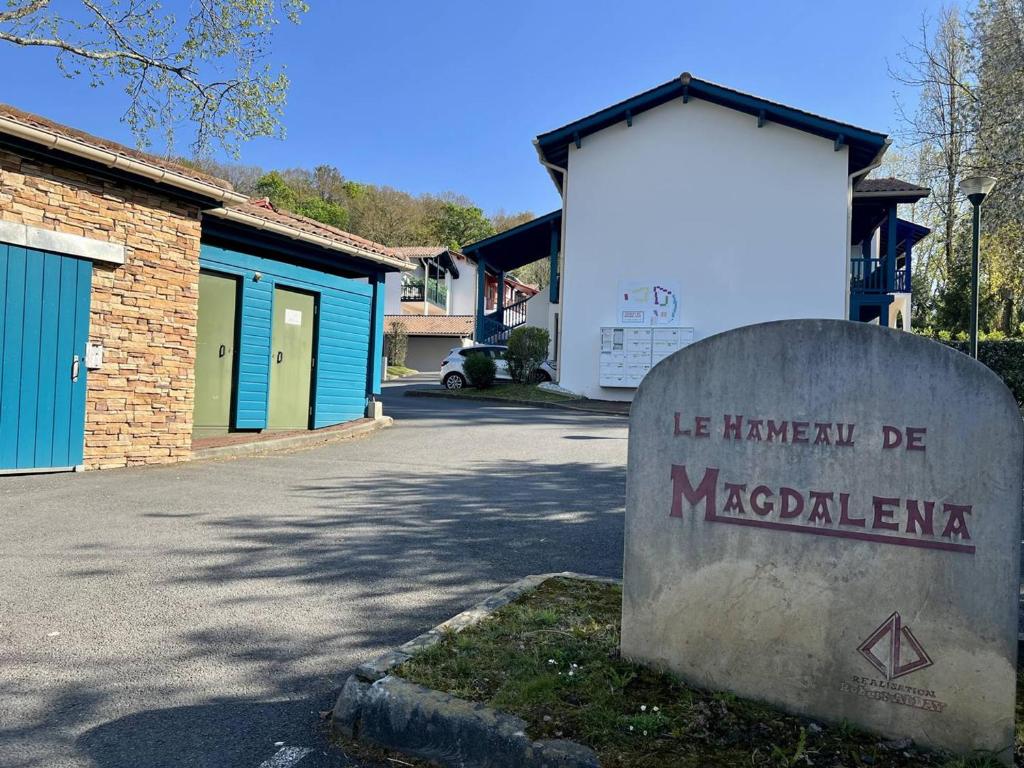 a sign in front of a building next to a street at Appartement T2 à Cambo-les-Bains avec piscine, terrasse et parking privé, proche des thermes - FR-1-495-82 in Cambo-les-Bains