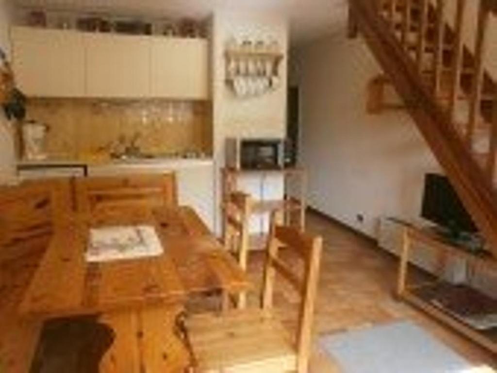 une salle à manger avec une table en bois et une cuisine dans l'établissement Duplex T2 cosy 6 pers, parking, centre St-Lary-Soulan - FR-1-457-147, à Saint-Lary-Soulan