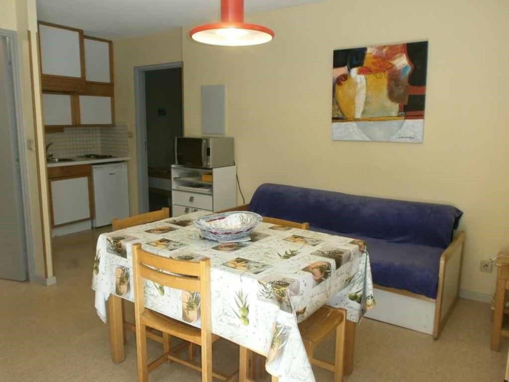een woonkamer met een tafel en een blauwe bank bij Appartement Saint-Lary-Soulan, 2 pièces, 6 personnes - FR-1-457-230 in Saint-Lary-Soulan