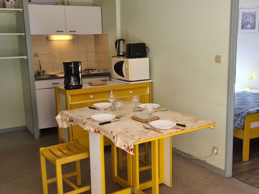a kitchen with a table with plates on it at Appartement Saint-Lary-Soulan, 2 pièces, 6 personnes - FR-1-457-253 in Saint-Lary-Soulan