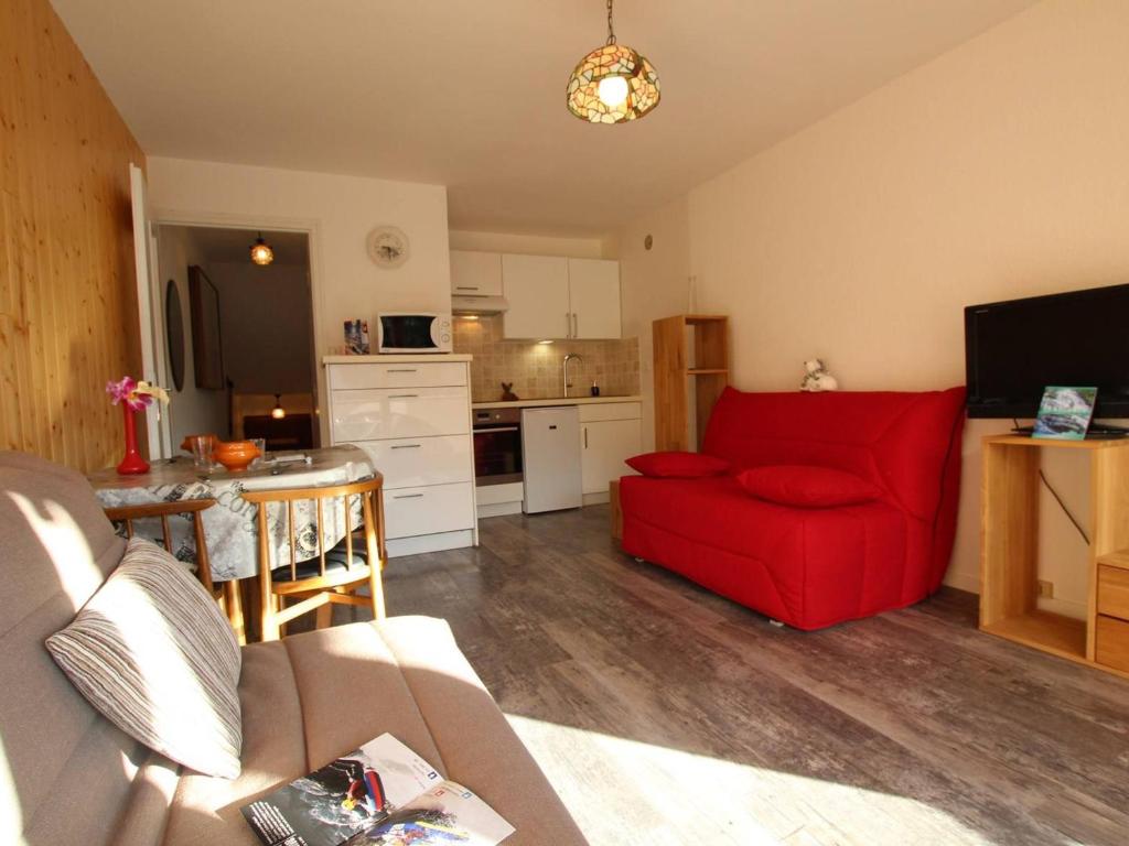 a living room with a red couch and a kitchen at Appartement Puy-Saint-Vincent, 1 pièce, 2 personnes - FR-1-330G-98 in Puy-Saint-Vincent
