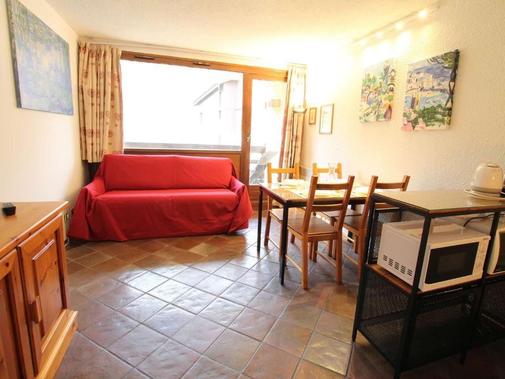un salon avec un canapé rouge et une table dans l'établissement Appartement familial sur les pistes avec parking et casier à skis - Montgenèvre - FR-1-330D-91, à Montgenèvre