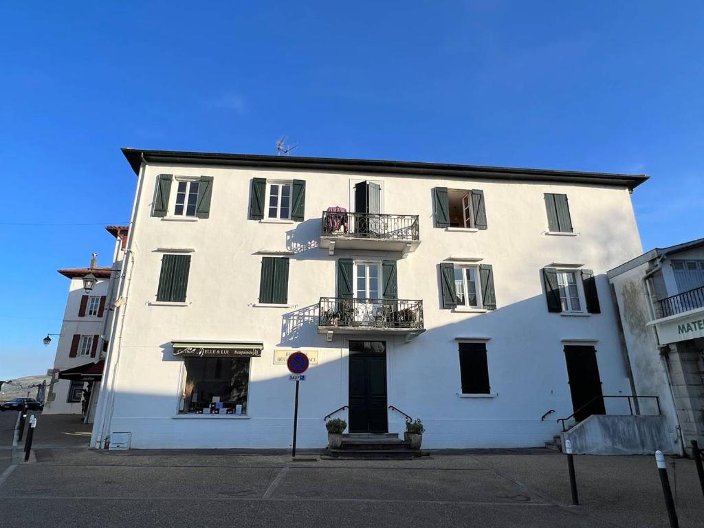 a white building with two balconies on a street at Appartement Cambo-les-Bains, 2 pièces, 3 personnes - FR-1-495-79 in Cambo-les-Bains