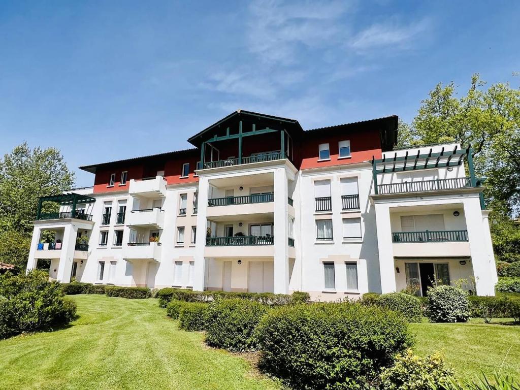 un gran edificio blanco con techo rojo en Appartement Cambo-les-Bains, 2 pièces, 2 personnes - FR-1-495-57 en Cambo-les-Bains