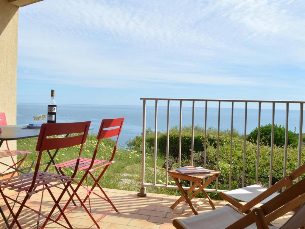 a patio with chairs and a table with a view of the ocean at Appart T2 avec terrasse, parking, WIFI, animaux admis - FR-1-225C-31 in Banyuls-sur-Mer