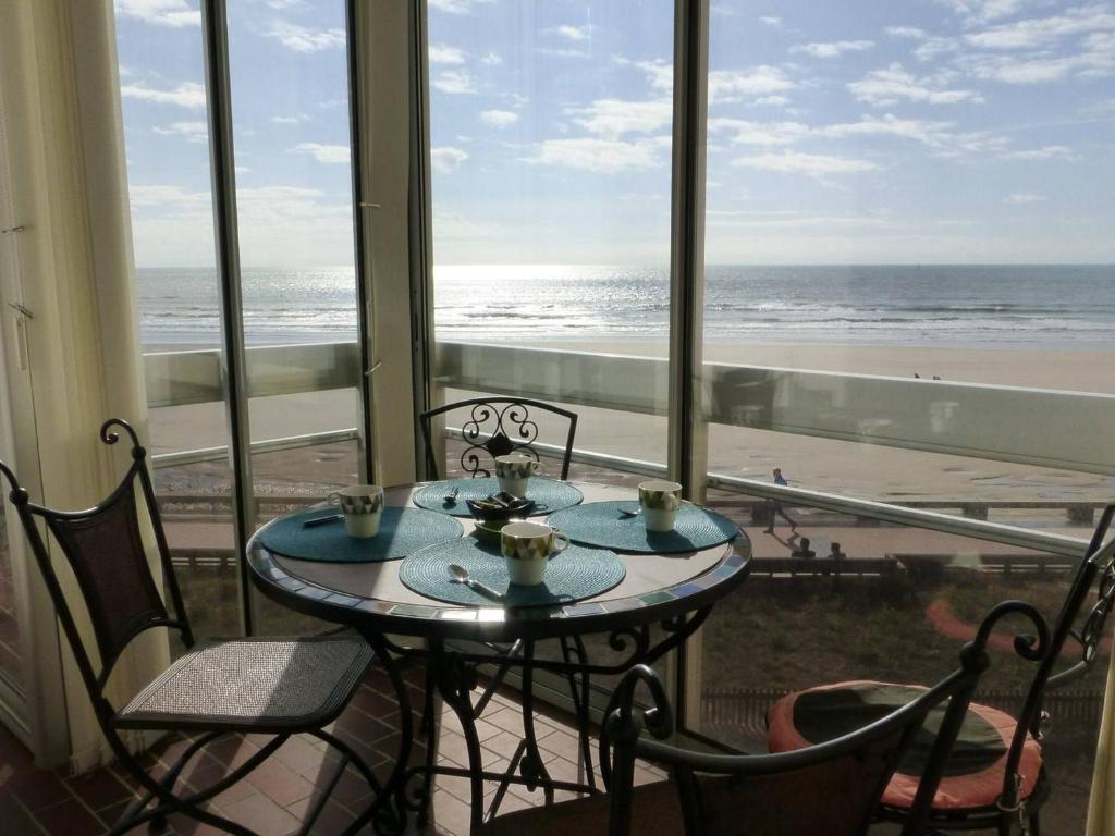 - une table et des chaises dans une chambre avec vue sur la plage dans l'établissement Appartement bord de mer 2 pièces avec parking à Saint-Gilles-Croix-de-Vie - FR-1-224-764, à Saint-Gilles-Croix-de-Vie