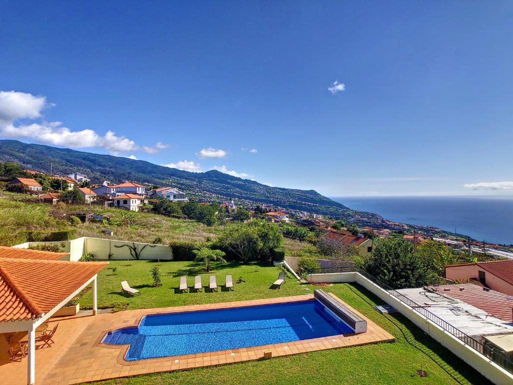 a villa with a swimming pool and a view of the ocean at Villa Baradaye by LovelyStay in Estreito da Calheta