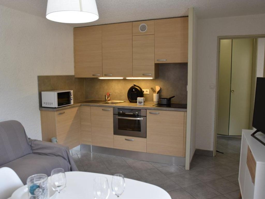 a kitchen with a couch and a table with wine glasses at Appartement Montgenèvre, 2 pièces, 6 personnes - FR-1-266-145 in Montgenèvre