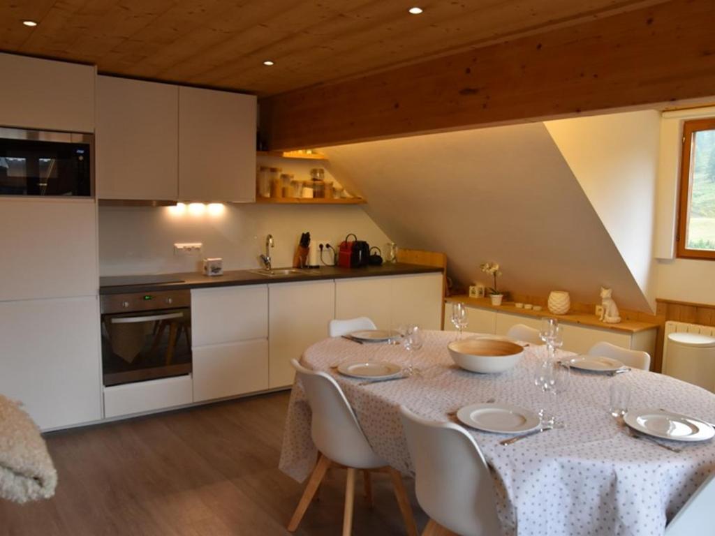 une salle à manger avec une table et une cuisine dans l'établissement Superbe appart 3 pièces, cuisine équipée, Wi-Fi, face aux pistes - FR-1-266-167, à Montgenèvre