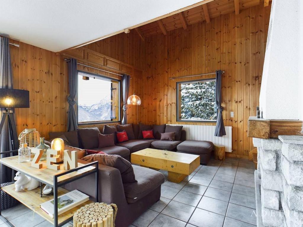 un salon avec un canapé et une cheminée dans l'établissement Superbe Duplex Savoyard pour 13 pers. avec Cheminée et Balcons, à 300m des Pistes - FR-1-398-616, à Montvalezan