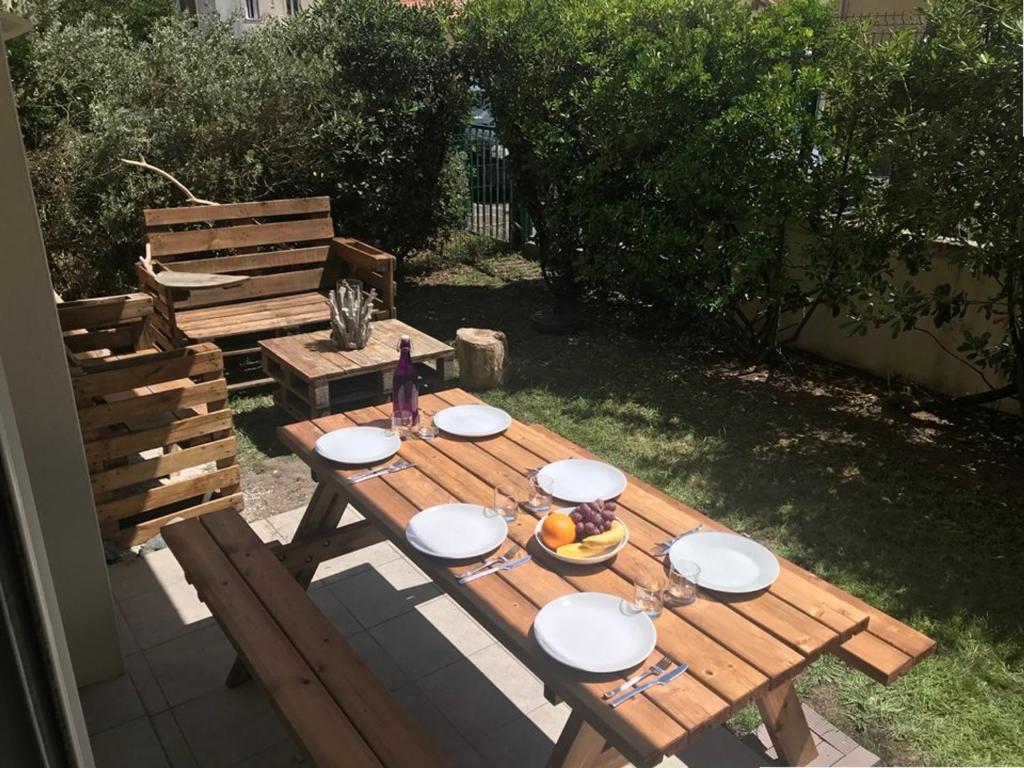 una mesa de picnic de madera con platos de comida. en Appartement Capbreton, 2 pièces, 4 personnes - FR-1-413-107 en Capbreton