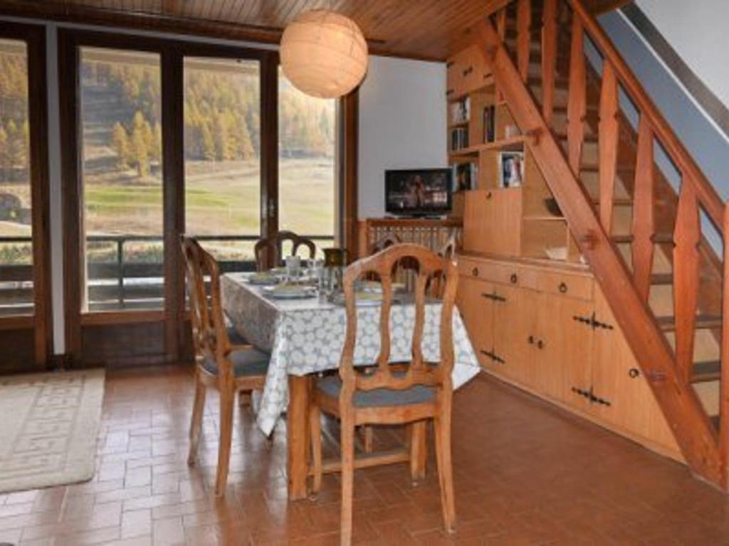 a dining room with a table and chairs and a staircase at Appartement Montgenèvre, 3 pièces, 6 personnes - FR-1-266-157 in Montgenèvre